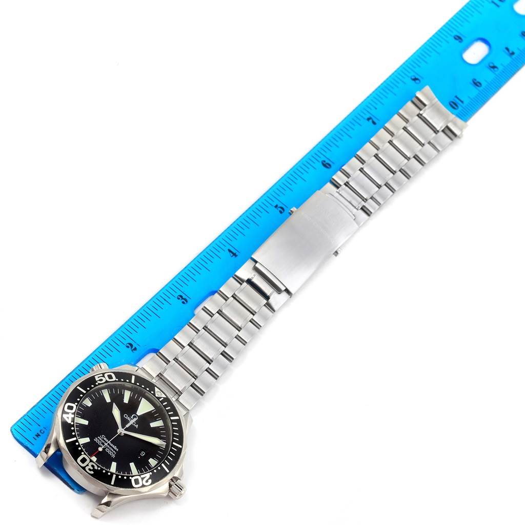 The image shows an Omega Seamaster 2264.50.00 Men
s Stainless Steel Black Dial 2264.50.00 Men
s Stainless Steel Black Dial watch laid flat with a blue ruler beside it, displaying the face, bezel, and stainless steel bracelet.