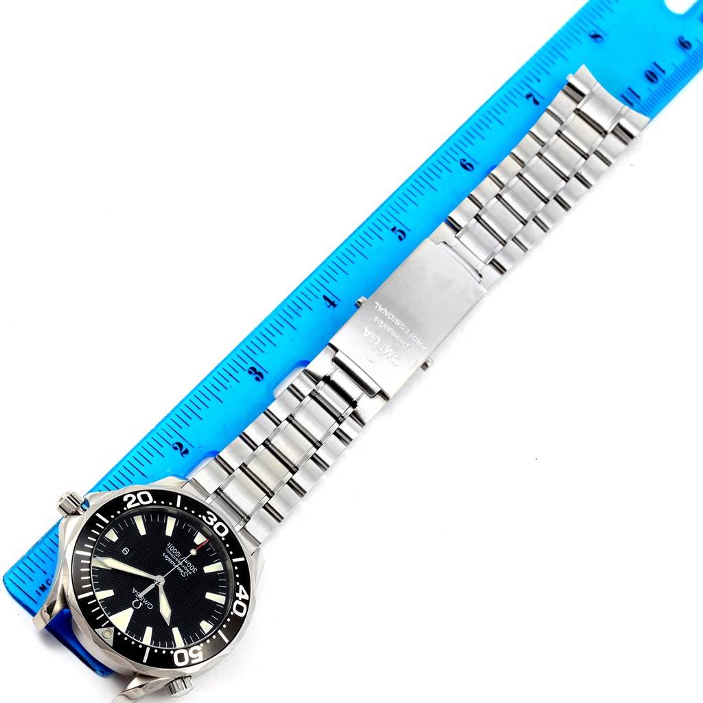 The image shows an Omega Seamaster 2264.50.00 Men
s Stainless Steel Black Dial 2264.50.00 Men
s Stainless Steel Black Dial watch laid flat alongside a blue ruler, highlighting the face, bezel, and part of the metal bracelet.