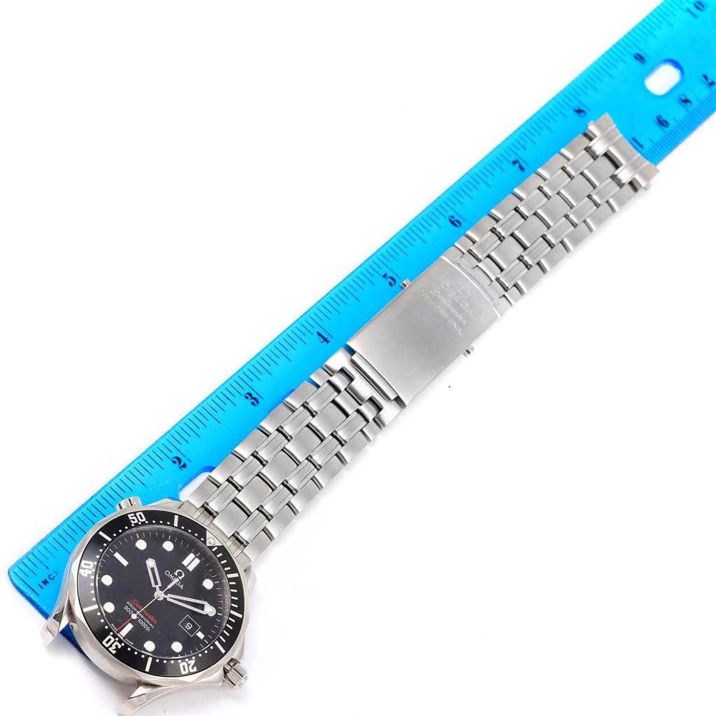 The Omega Seamaster 212.30.41.61.01.001 Men
s Stainless Steel Black Dial 212.30.41.61.01.001 Men
s Stainless Steel Black Dial watch is shown laid flat with its metal bracelet extended next to a blue ruler.