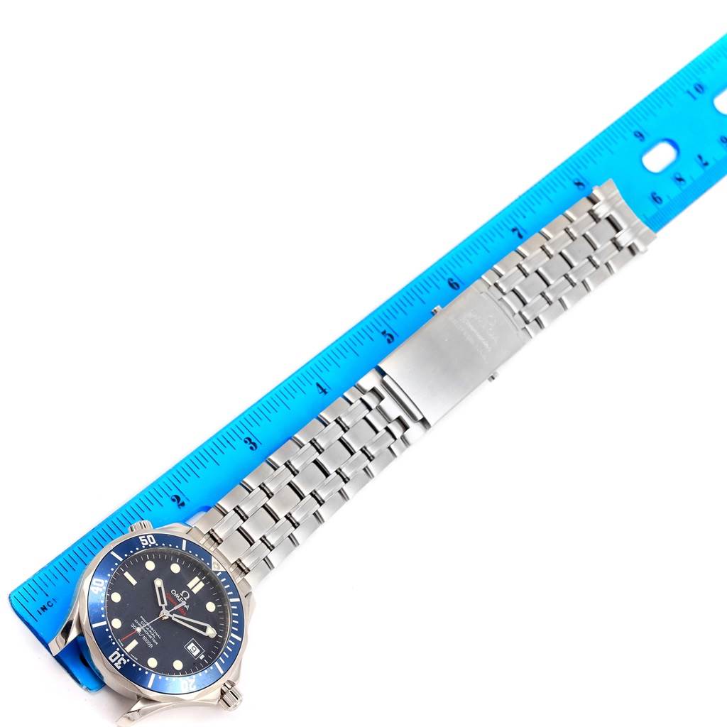 The Omega Seamaster 2220.80.00 Men
s Stainless Steel Blue Dial 2220.80.00 Men
s Stainless Steel Blue Dial watch is displayed with its stainless steel bracelet and clasp alongside a blue ruler for scale.