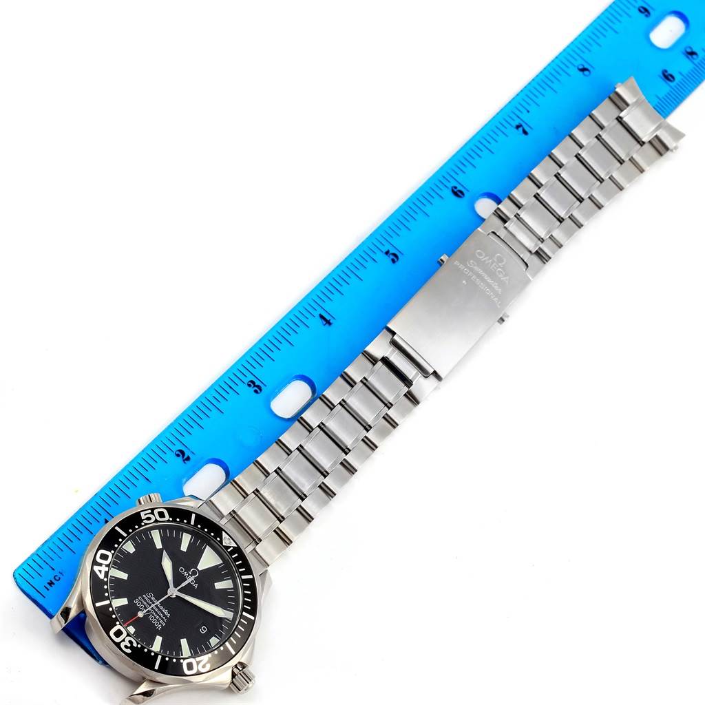 The image shows an Omega Seamaster 2254.50.00 Men
s Stainless Steel Black Dial 2254.50.00 Men
s Stainless Steel Black Dial watch laying flat with the face, bezel, and stainless steel bracelet visible adjacent to a blue ruler.