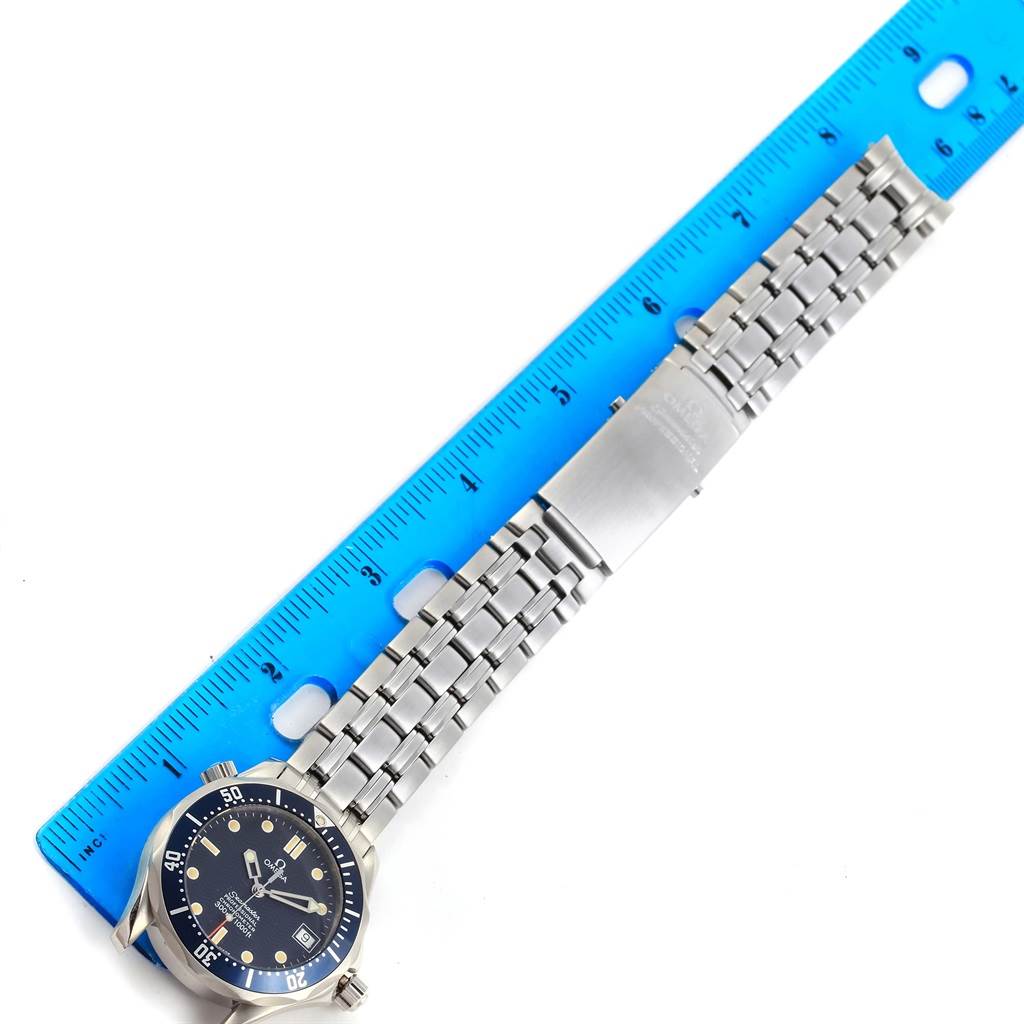 The image shows an Omega Seamaster 2551.80.00 Men
s Stainless Steel Blue Dial 2551.80.00 Men
s Stainless Steel Blue Dial watch laid flat with its stainless steel bracelet next to a blue ruler.