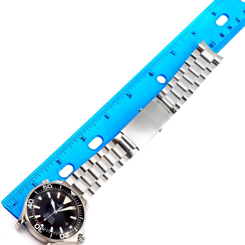 The Omega Seamaster 2254.50.00 Men
s Stainless Steel Black Dial 2254.50.00 Men
s Stainless Steel Black Dial watch is shown from the top view alongside a blue ruler, displaying its face and metal bracelet.