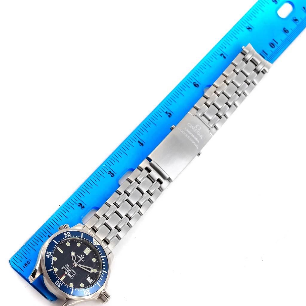 The image shows an Omega Seamaster 2551.80.00 Men
s Stainless Steel Blue Dial 2551.80.00 Men
s Stainless Steel Blue Dial wristwatch and its metal bracelet, placed next to a blue ruler for scale.