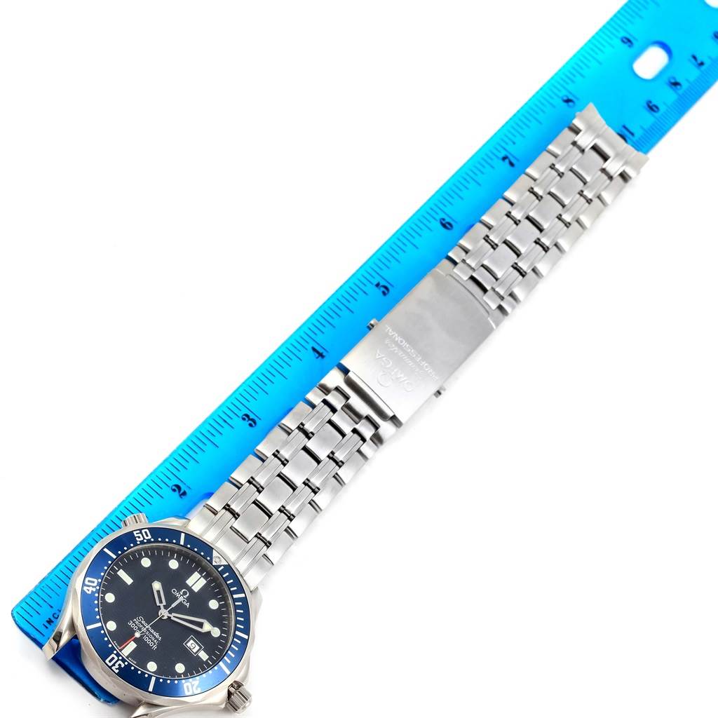 The Omega Seamaster 2541.80.00 Men
s Stainless Steel Blue Dial 2541.80.00 Men
s Stainless Steel Blue Dial watch is shown flat with its full face, bezel, and metal bracelet alongside a blue ruler.