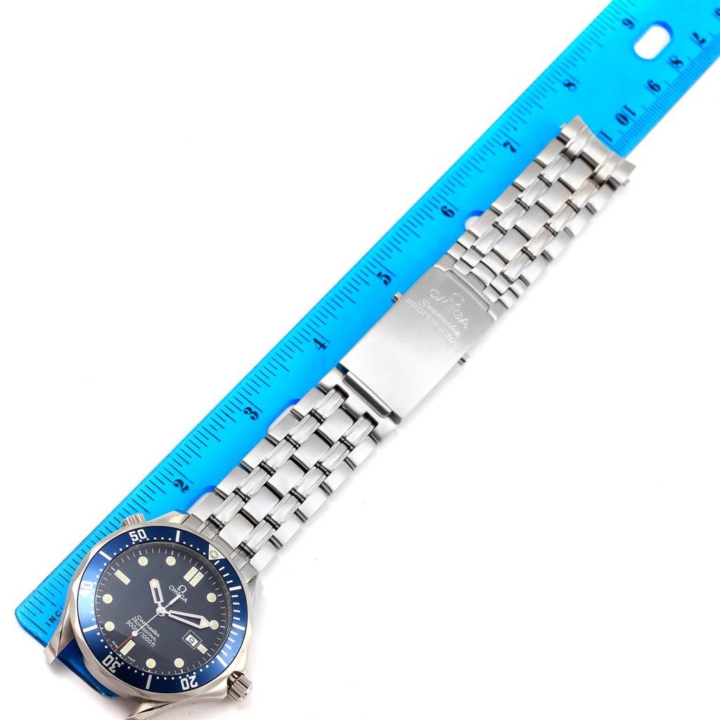 The image shows an Omega Seamaster 2541.80.00 Men
s Stainless Steel Blue Dial 2541.80.00 Men
s Stainless Steel Blue Dial watch lying flat with its stainless steel bracelet and clasp, alongside a blue ruler for scale.