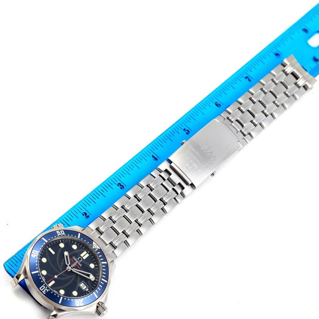 The image shows the Omega Seamaster 2226.80.00 Men's Stainless Steel Blue Dial 2226.80.00 Men's Stainless Steel Blue Dial watch face and bracelet alongside a blue measurement ruler, taken from a top-down angle.