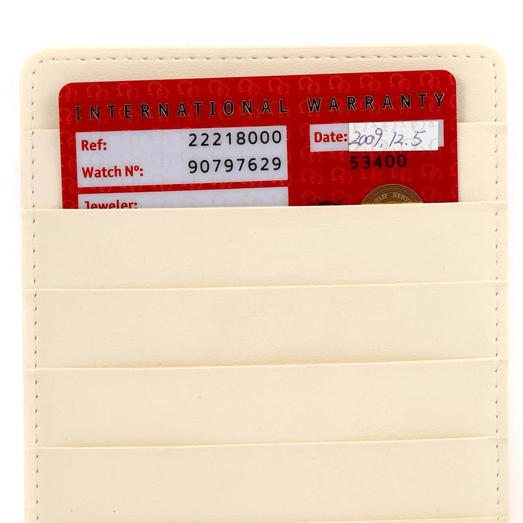 The image shows an Omega Seamaster 2221.80.00 Men
s Stainless Steel Blue Dial 2221.80.00 Men
s Stainless Steel Blue Dial International Warranty card partially tucked into a beige slot holder.