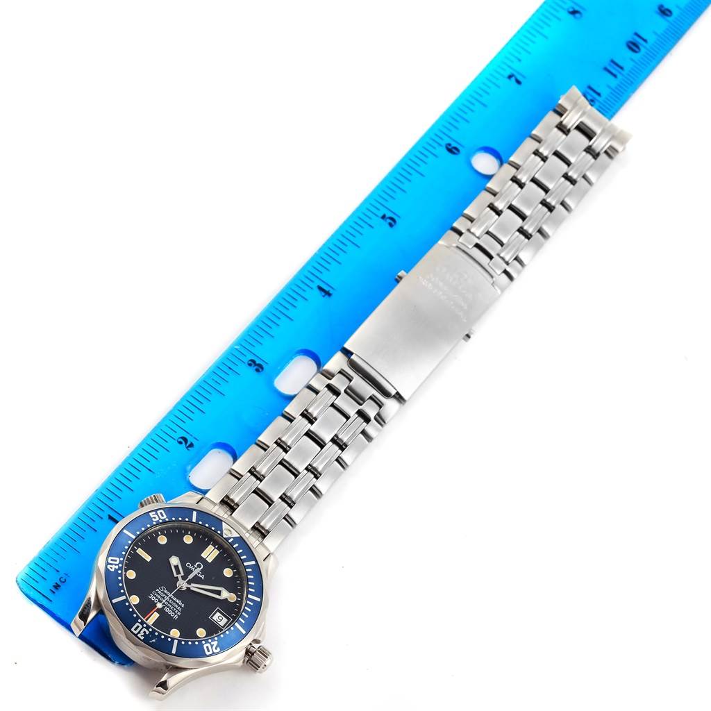 A top-down view of the Omega Seamaster 2551.80.00 Men
s Stainless Steel Blue Dial 2551.80.00 Men
s Stainless Steel Blue Dial watch is shown, with its face, bezel, and metal bracelet aligned with a blue ruler.