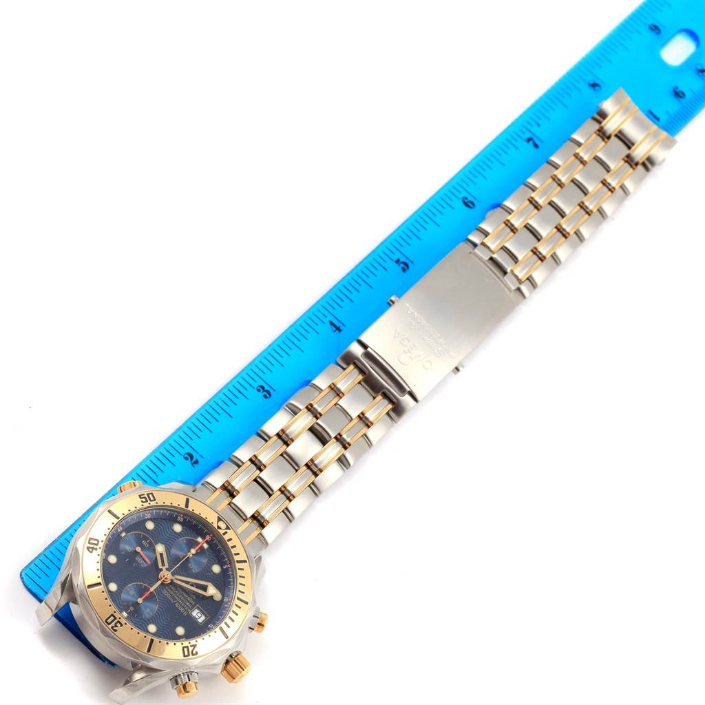 The image shows an Omega Seamaster 2398.80.00 Men's Steel and Gold (two tone) Blue Dial 2398.80.00 Men's Steel and Gold (two tone) Blue Dial watch and part of its bracelet laid next to a blue ruler for measurement.