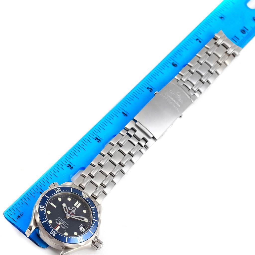 The image shows an Omega Seamaster 2222.80.00 Men
s Stainless Steel Blue Dial 2222.80.00 Men
s Stainless Steel Blue Dial watch laid flat next to a blue ruler, displaying the entire watch including the face, bezel, and metal bracelet.