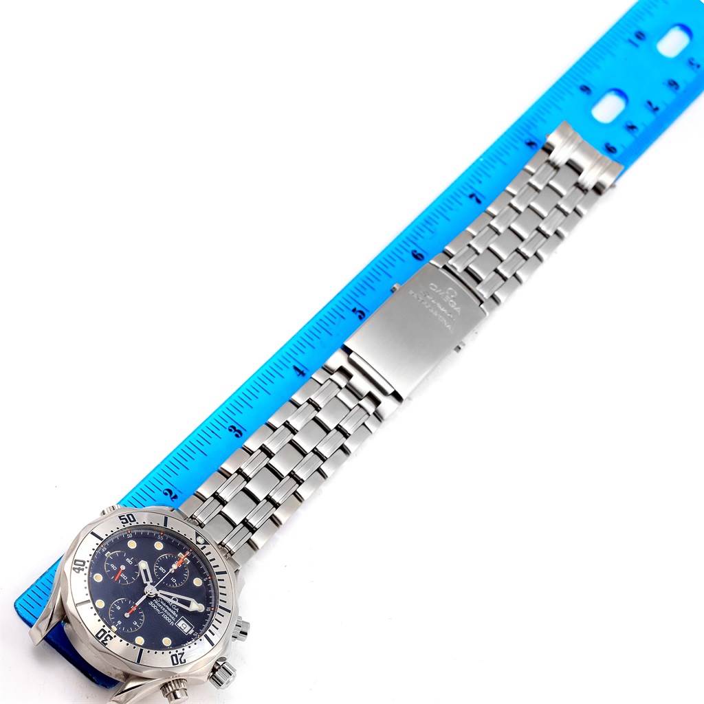 The image shows an Omega Seamaster 2598.80.00 Men
s Stainless Steel Blue Dial 2598.80.00 Men
s Stainless Steel Blue Dial watch laid flat with a blue ruler next to it, highlighting the watch face and stainless steel bracelet.