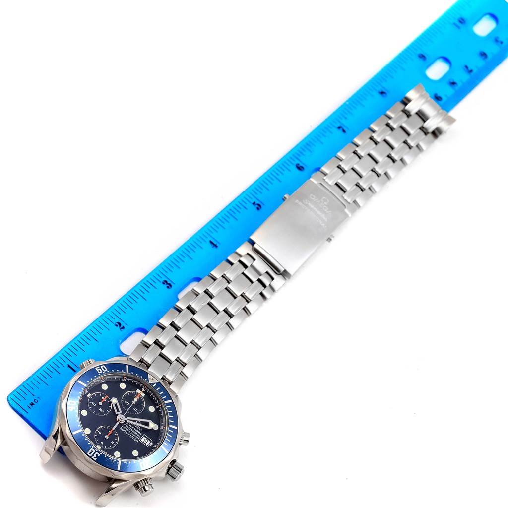 The image shows an Omega Seamaster 2599.80.00 Men's Stainless Steel Blue Dial 2599.80.00 Men's Stainless Steel Blue Dial watch laid out flat alongside a blue ruler for measurement.