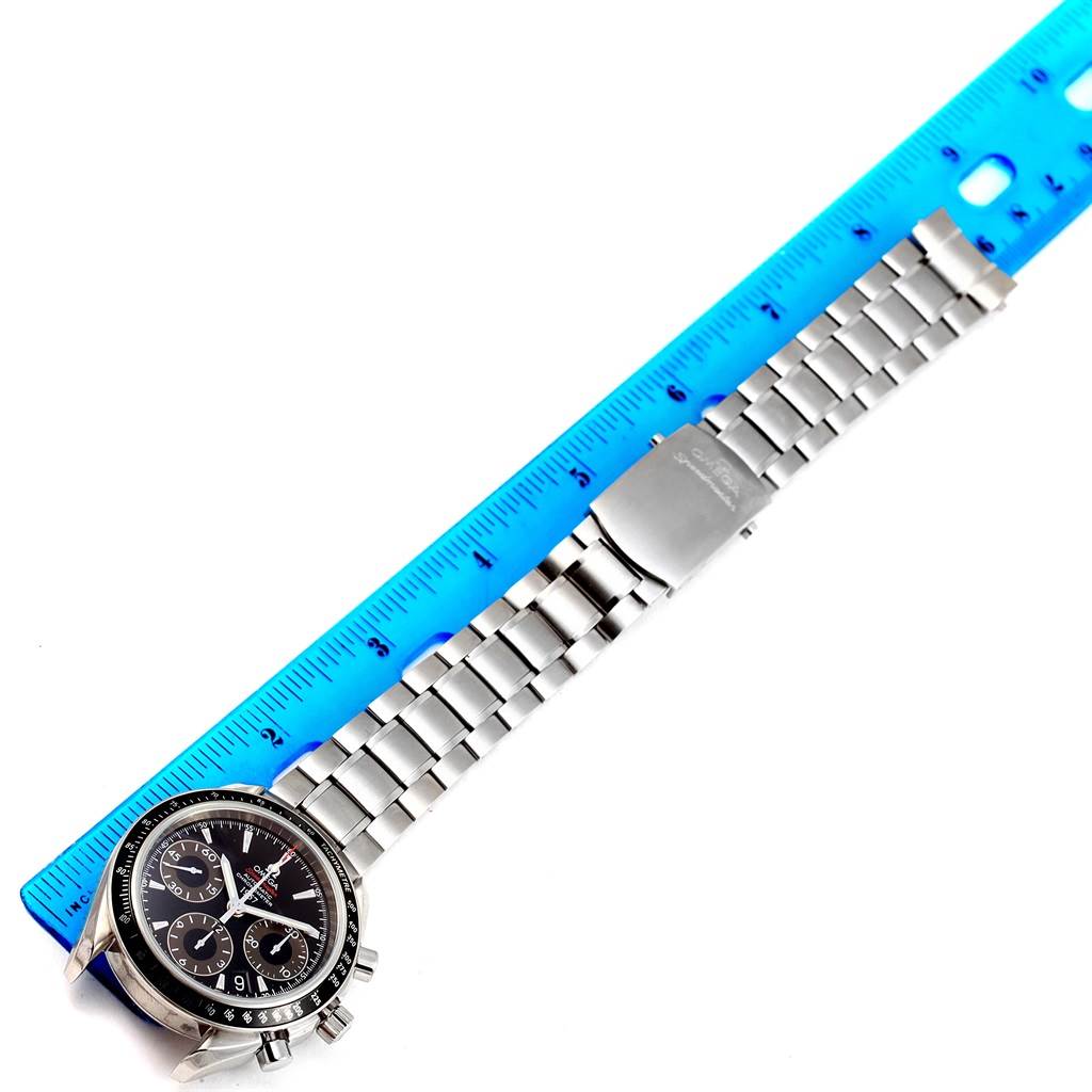 The Omega Seamaster 323.30.40.40.01.001 Men's Stainless Steel Black Dial 323.30.40.40.01.001 Men's Stainless Steel Black Dial watch is shown from a top-down angle, displaying the face and full metal bracelet with a blue ruler beside it.