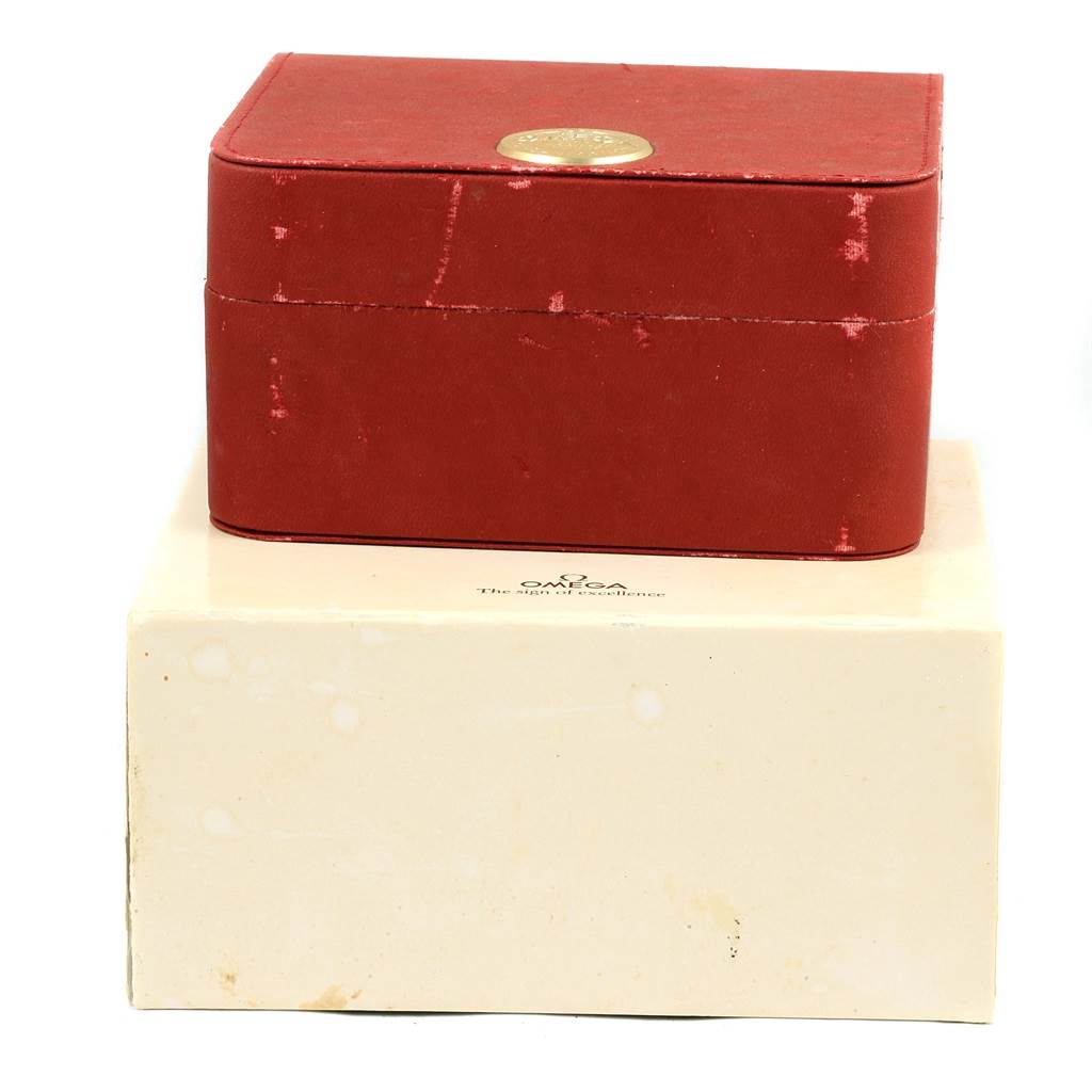 The image shows a closed red Omega Seamaster 2551.80.00 Men
s Stainless Steel Blue Dial 2551.80.00 Men
s Stainless Steel Blue Dial watch box placed on top of a cream-colored outer box.