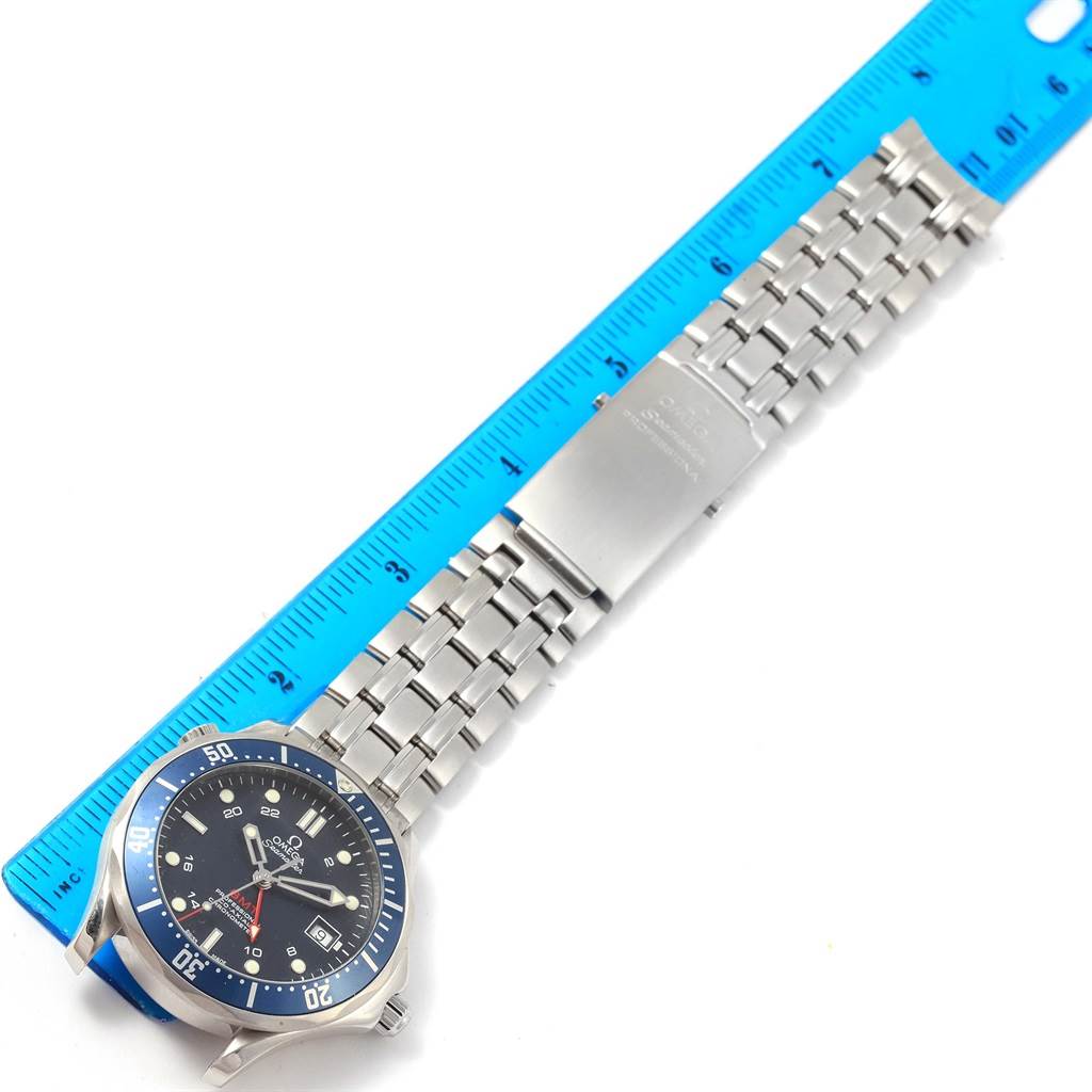 The image shows the full length of an Omega Seamaster 2535.80.00 Stainless Steel Blue Dial 2535.80.00 Stainless Steel Blue Dial watch, lying flat alongside a blue ruler, highlighting the face and metal bracelet.