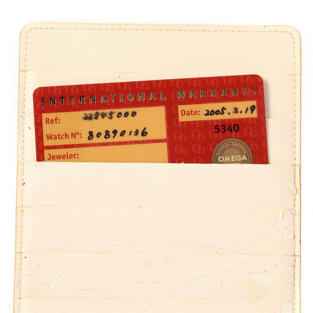 The image shows an Omega Seamaster 2254.50.00 Men
s Stainless Steel Black Dial 2254.50.00 Men
s Stainless Steel Black Dial International Warranty card partially inserted into a cream-colored wallet.