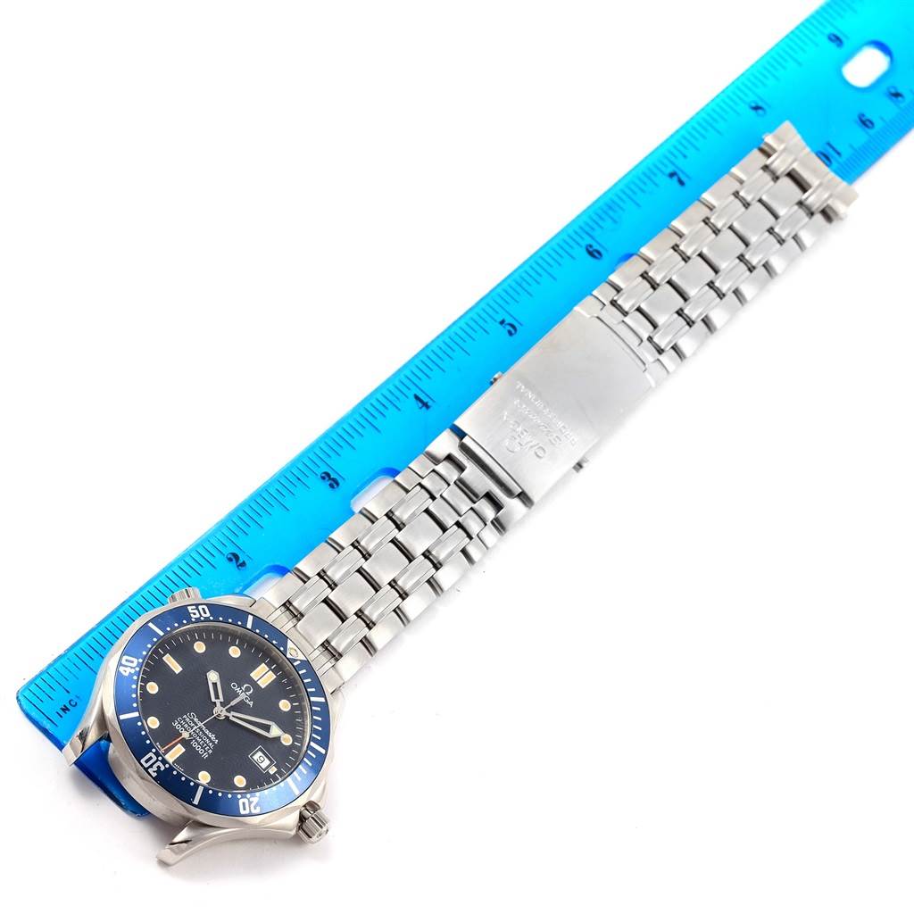 The image shows the front of an Omega Seamaster 2531.80.00 Men
s Stainless Steel Blue Dial 2531.80.00 Men
s Stainless Steel Blue Dial watch with a blue bezel, dial, and a metal bracelet, positioned next to a ruler.