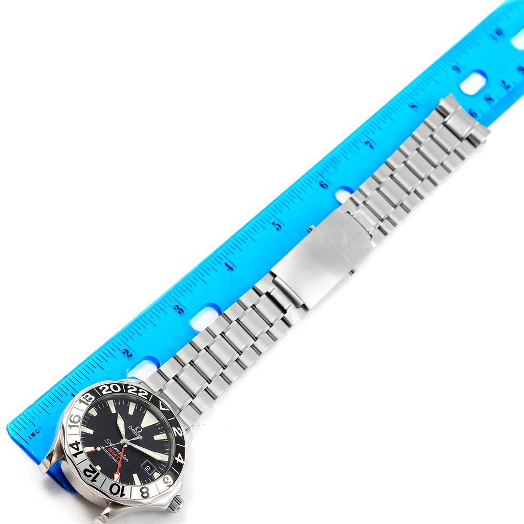 The image shows an Omega Seamaster 2536.50.00 Men's Stainless Steel Black Dial 2536.50.00 Men's Stainless Steel Black Dial watch laid flat with a metal bracelet next to a blue ruler for measurement.