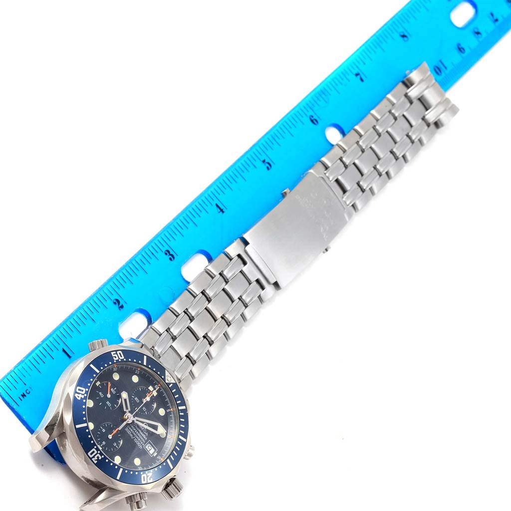 The image shows an Omega Seamaster 2599.80.00 Men
s Stainless Steel Blue Dial 2599.80.00 Men
s Stainless Steel Blue Dial watch laid flat with a metal bracelet next to a ruler.