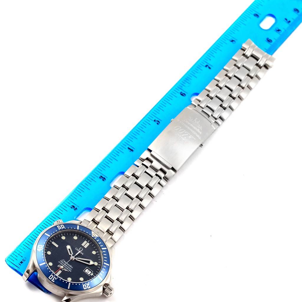 The image shows an Omega Seamaster 2537.80.00 Men
s Stainless Steel Blue Dial 2537.80.00 Men
s Stainless Steel Blue Dial watch laid flat next to a blue ruler, displaying the face, bezel, and full metal bracelet.