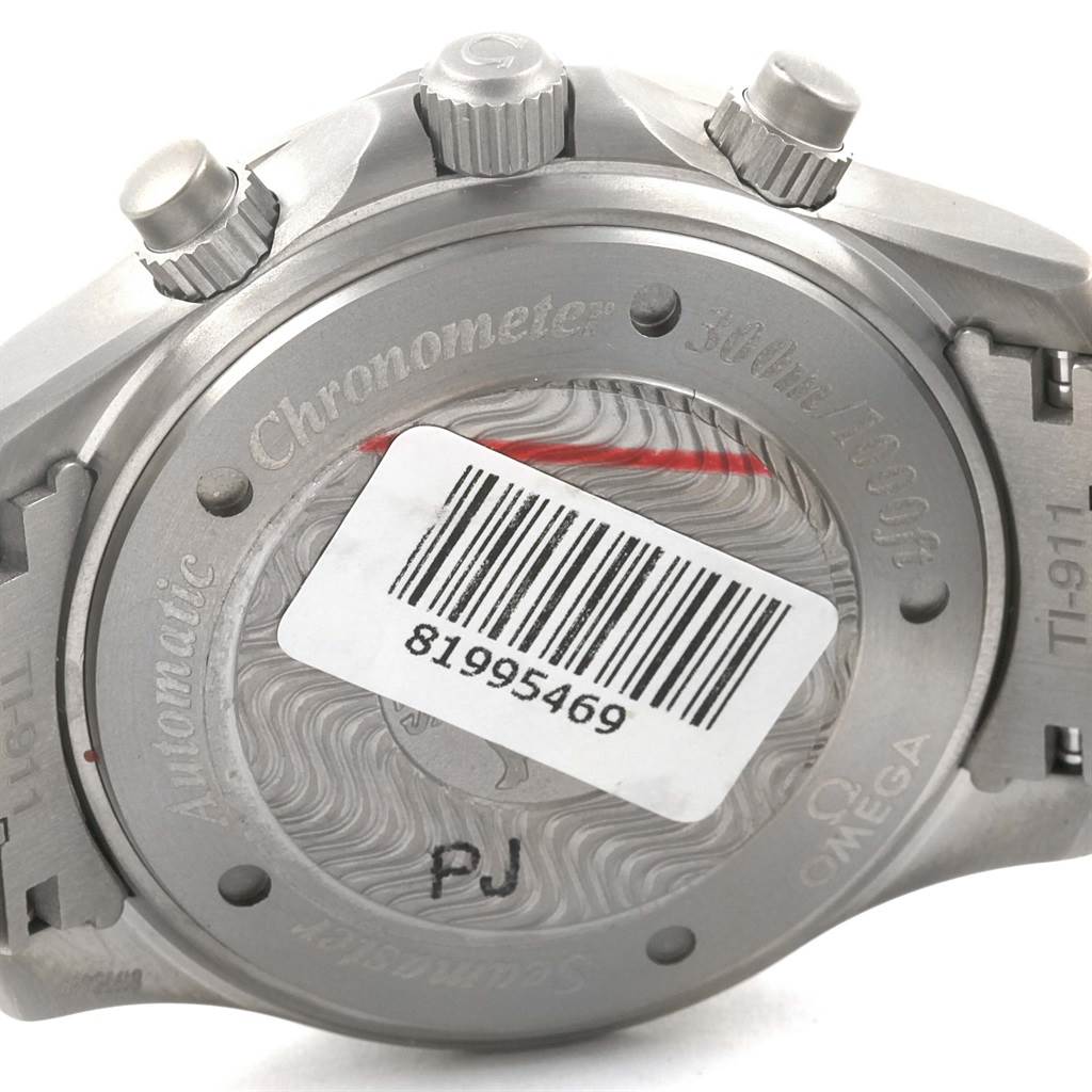 The image shows the back case and crown of an Omega Seamaster 2269.52.00 Men's Titanium Black Dial 2269.52.00 Men's Titanium Black Dial watch, featuring a barcode sticker and engraved details.