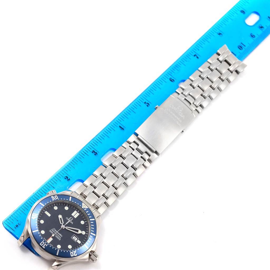 The image shows an Omega Seamaster 2541.80.00 Men
s Stainless Steel Blue Dial 2541.80.00 Men
s Stainless Steel Blue Dial watch laid flat beside a blue ruler, displaying the face, bezel, and metal bracelet.