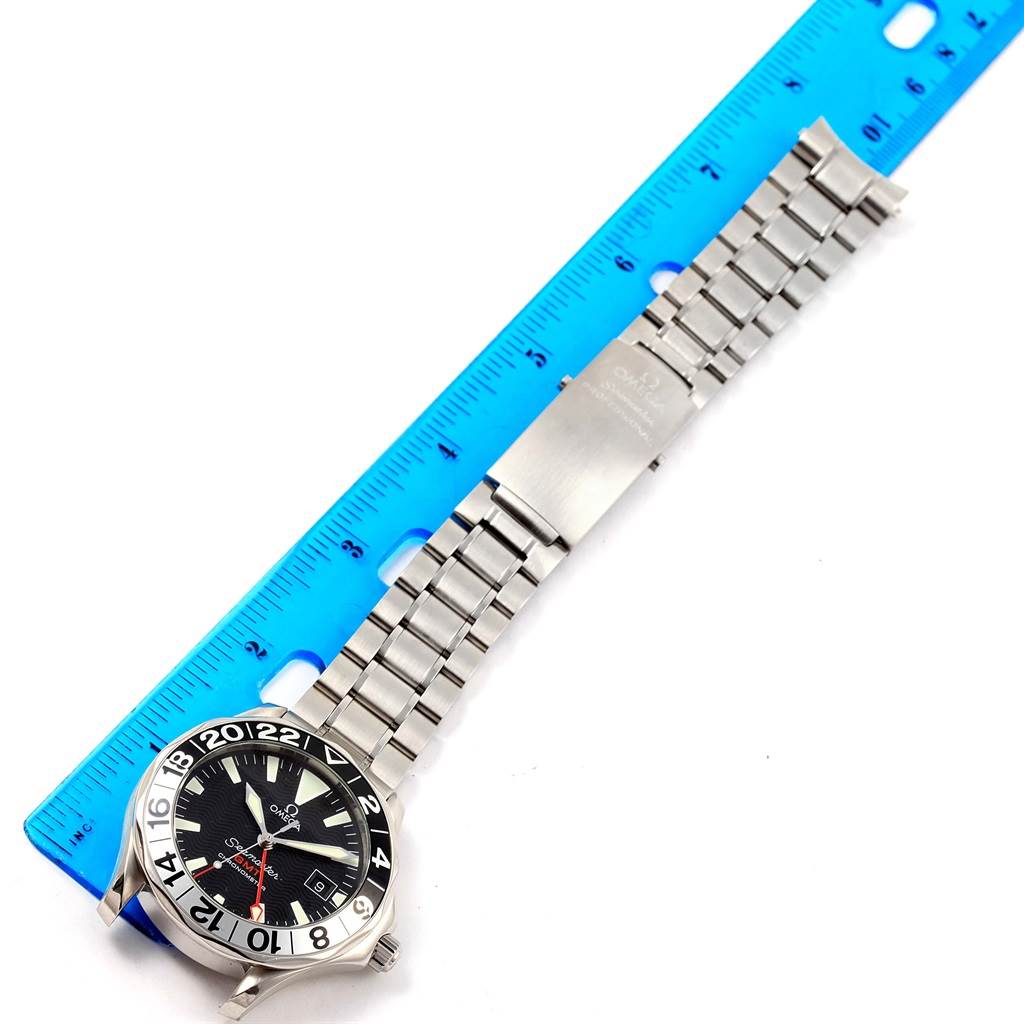 This image shows an Omega Seamaster 2536.50.00 Men
s Stainless Steel Black Dial 2536.50.00 Men
s Stainless Steel Black Dial watch with a stainless steel bracelet and clasp, placed beside a blue ruler for scale.