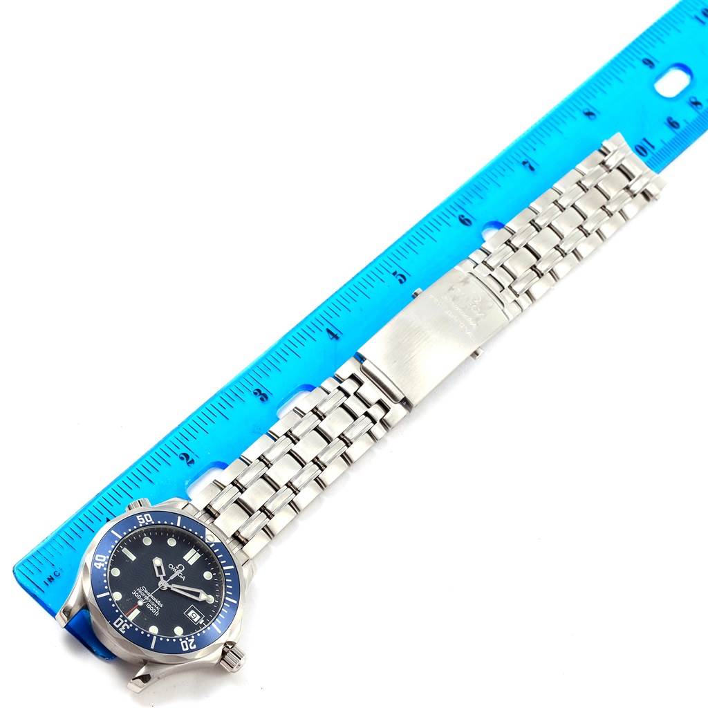 The image shows an Omega Seamaster 2561.80.00 Men's Stainless Steel Blue Dial 2561.80.00 Men's Stainless Steel Blue Dial watch laid flat next to a ruler, highlighting its stainless steel bracelet and face, viewed from above.