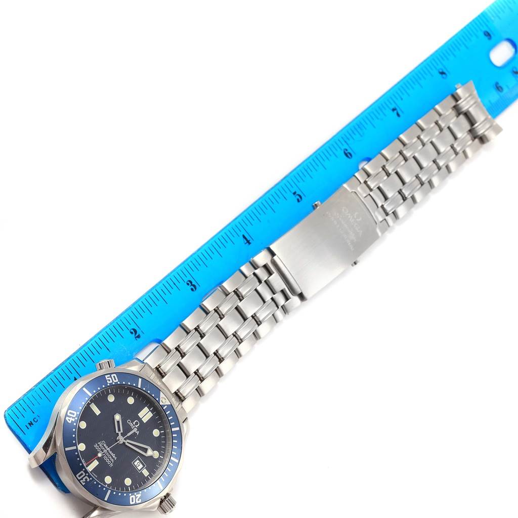 This image shows the Omega Seamaster 2541.80.00 Men
s Stainless Steel Blue Dial 2541.80.00 Men
s Stainless Steel Blue Dial watch lying alongside a blue ruler, displaying its stainless steel bracelet and watch face.