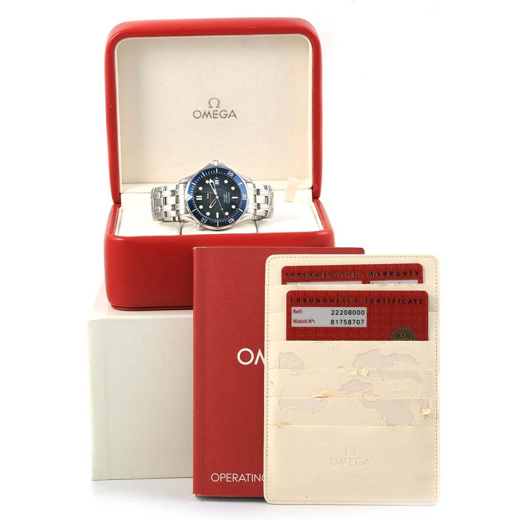 The image shows an Omega Seamaster 2220.80.00 Men
s Stainless Steel Blue Dial 2220.80.00 Men
s Stainless Steel Blue Dial watch in its box along with warranty cards, chronometer certificate, and operating instructions booklet.