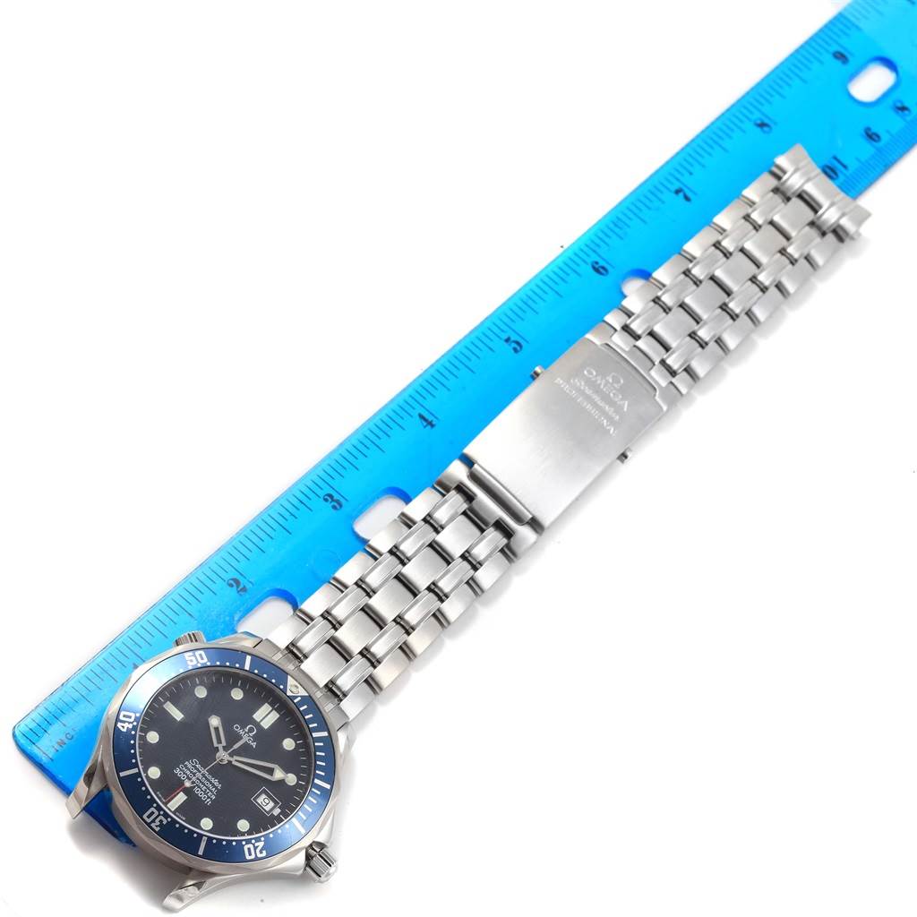 The image shows an aerial view of an Omega Seamaster 2531.80.00 Men
s Stainless Steel Blue Dial 2531.80.00 Men
s Stainless Steel Blue Dial watch with its stainless steel bracelet fully extended next to a blue ruler.