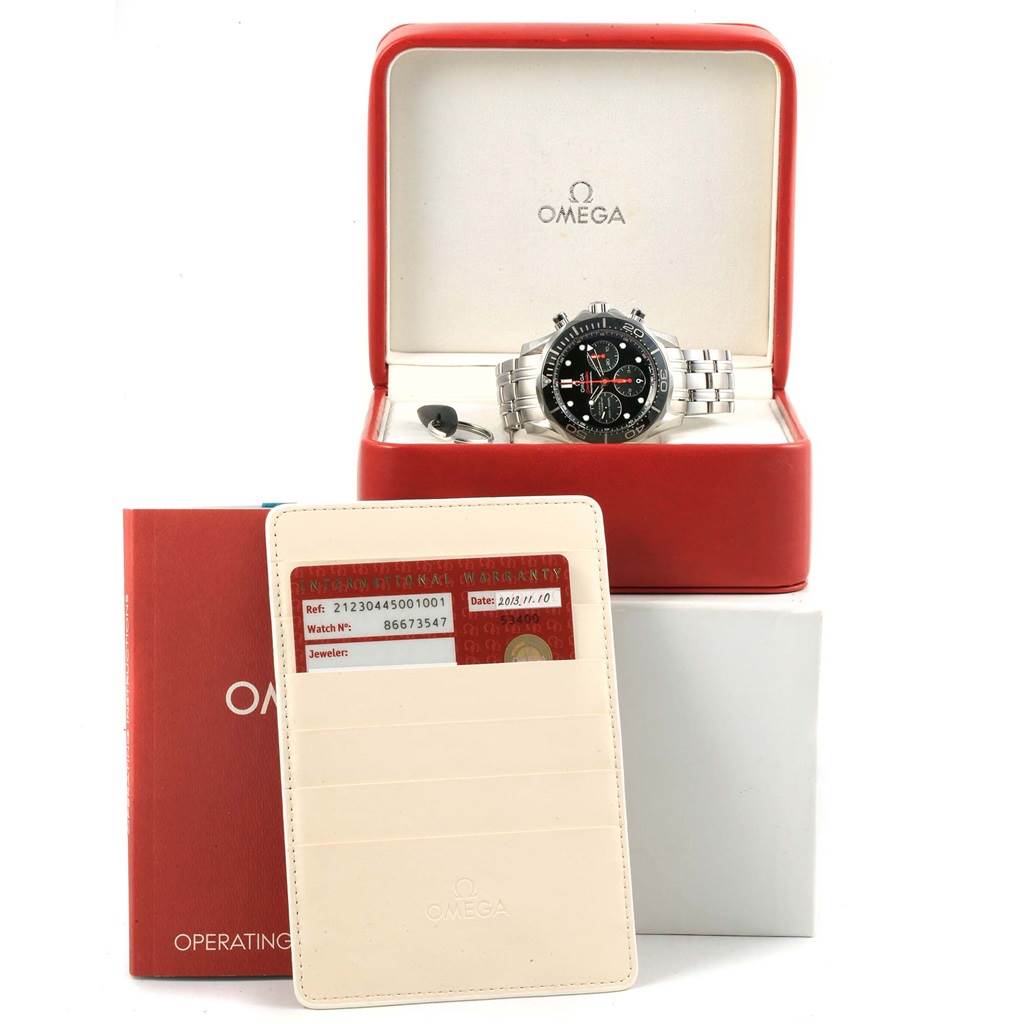 The image shows the Omega Seamaster 212.30.44.50.01.001 Men
s Stainless Steel Black Dial 212.30.44.50.01.001 Men
s Stainless Steel Black Dial watch in its box, along with its warranty card, cardholder, and operating instructions.