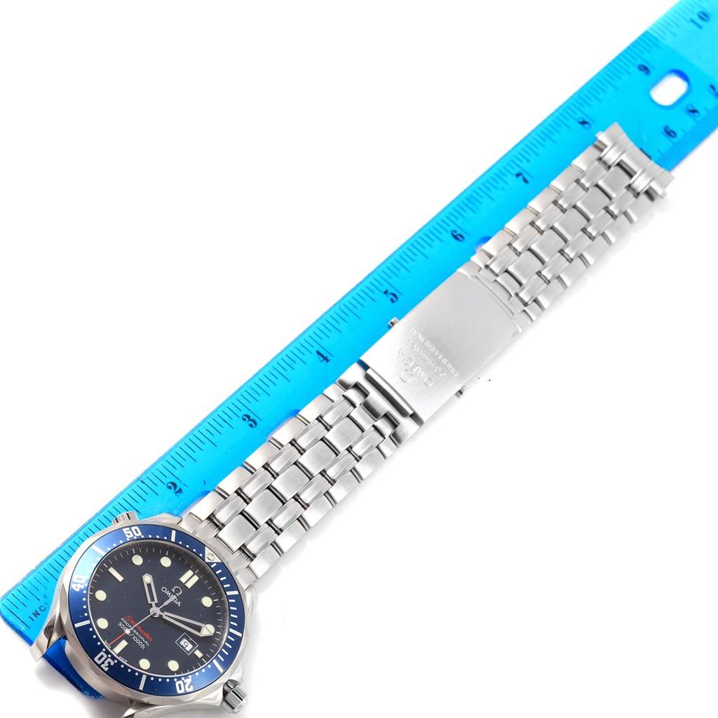 The Omega Seamaster 2221.80.00 Men
s Stainless Steel Blue Dial 2221.80.00 Men
s Stainless Steel Blue Dial watch is shown flat with its blue bezel, dark dial, and stainless-steel bracelet next to a blue ruler.