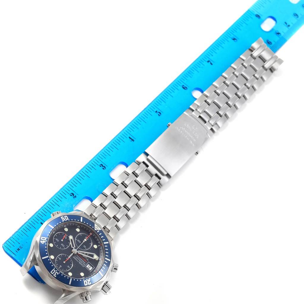 The Omega Seamaster 2225.80.00 Men
s Stainless Steel Blue Dial 2225.80.00 Men
s Stainless Steel Blue Dial watch is shown laid flat, displaying its face and metal bracelet alongside a blue ruler for scale.