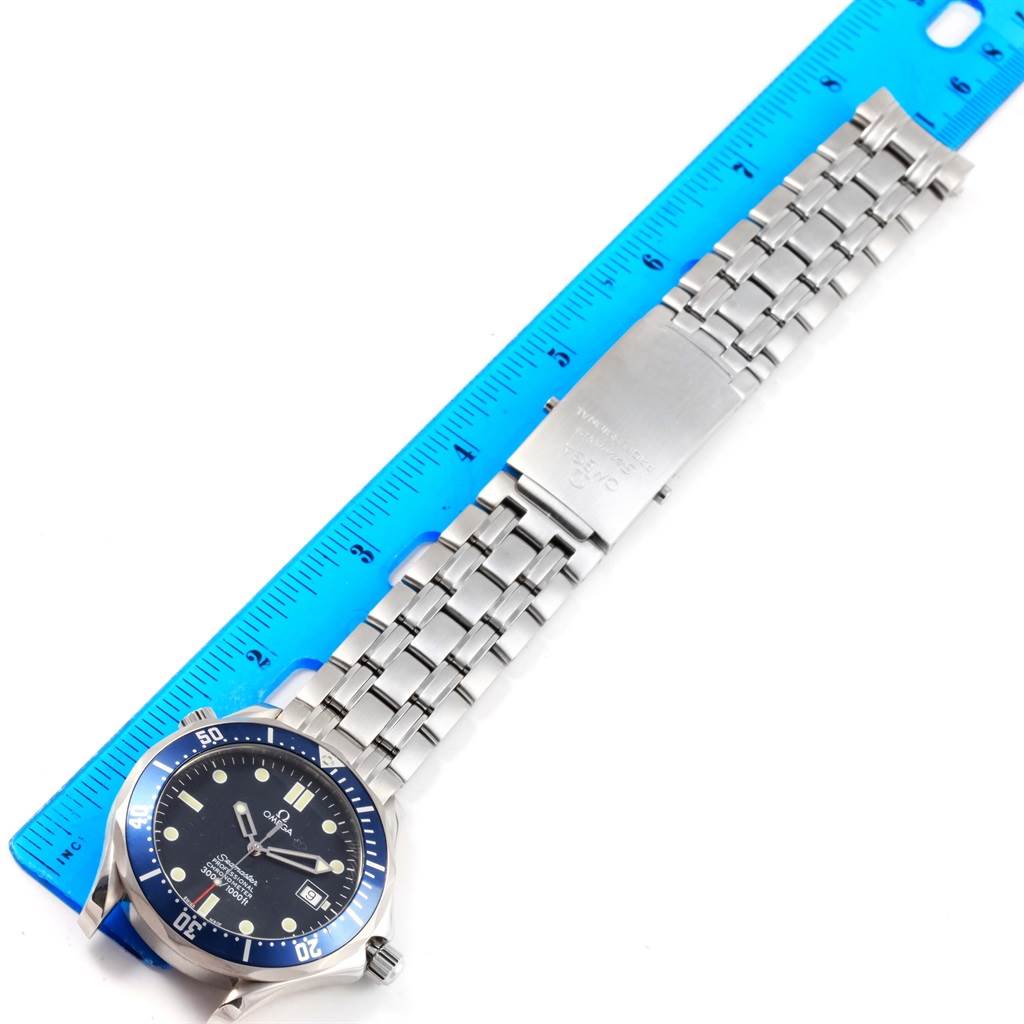 The image shows an Omega Seamaster 2531.80.00 Men
s Stainless Steel Blue Dial 2531.80.00 Men
s Stainless Steel Blue Dial watch, with a focus on the stainless steel bracelet and clasp, alongside a blue ruler.