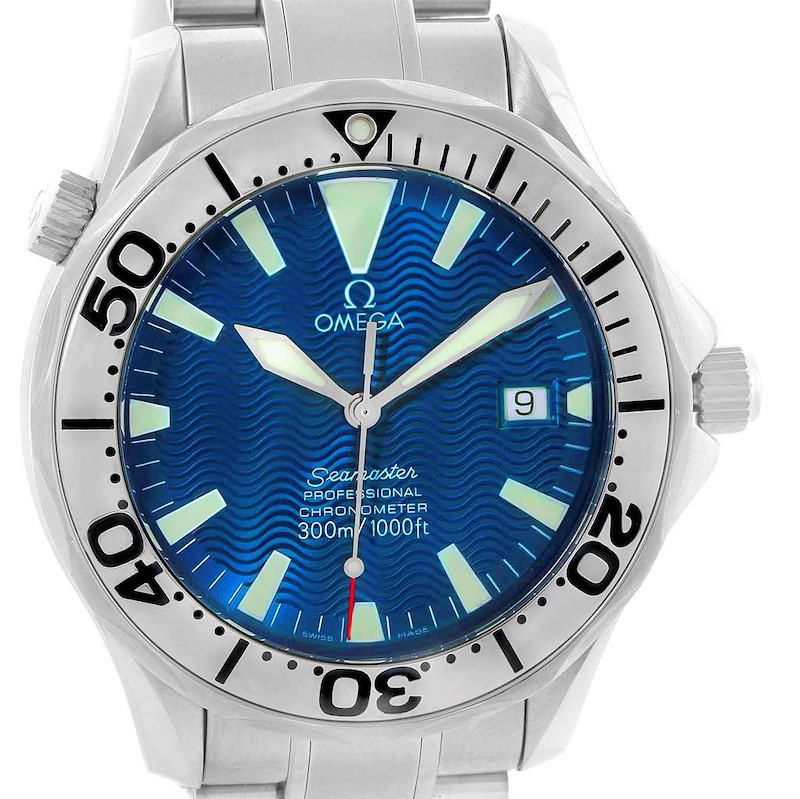 The Omega Seamaster watch is shown from a front angle, displaying its blue dial, hands, date window, and part of the stainless steel bracelet.