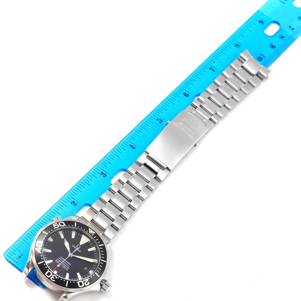 The image shows an Omega Seamaster 2254.50.00 Men
s Stainless Steel Black Dial 2254.50.00 Men
s Stainless Steel Black Dial watch lying flat with its face, bezel, bracelet, and clasp visible alongside a ruler for size reference.