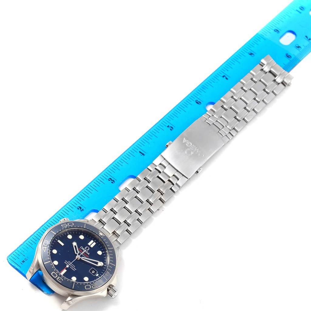 The image shows an Omega Seamaster 212.30.41.20.03.001 Men
s Stainless Steel Blue Dial 212.30.41.20.03.001 Men
s Stainless Steel Blue Dial watch laid flat next to a blue ruler, displaying the face, bracelet, and clasp.