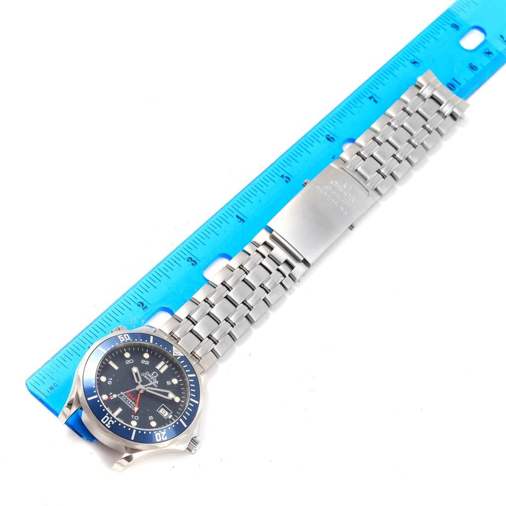 The Omega Seamaster 2535.80.00 Men
s Stainless Steel Blue Dial 2535.80.00 Men
s Stainless Steel Blue Dial watch is shown laying flat with the dial, bezel, and bracelet visible, alongside a blue ruler.