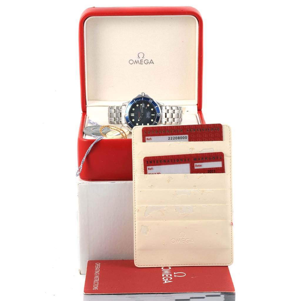 The image shows an Omega Seamaster 2220.80.00 Men
s Stainless Steel Blue Dial 2220.80.00 Men
s Stainless Steel Blue Dial watch in its open box with warranty cards and a user manual displayed in front.