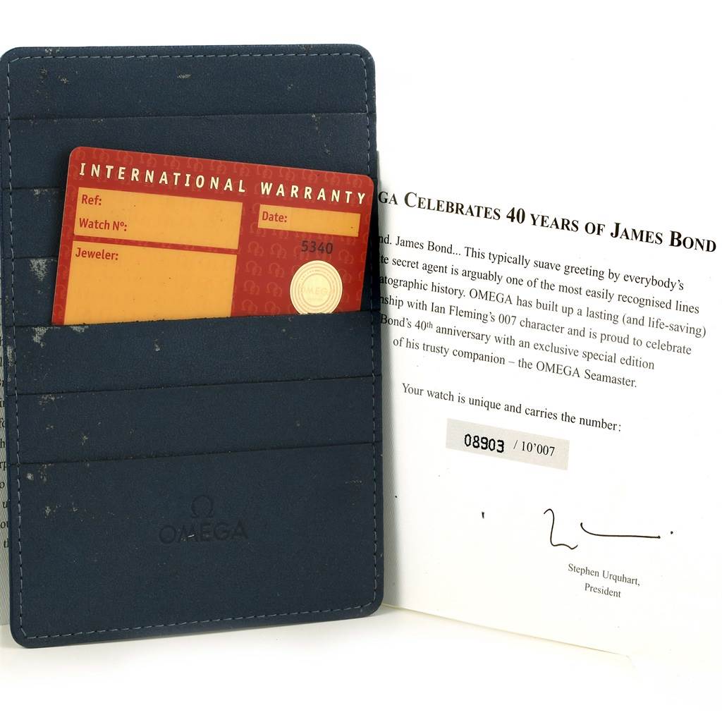 The image shows an Omega Seamaster 2537.80.00 Men's Stainless Steel Blue Dial 2537.80.00 Men's Stainless Steel Blue Dial warranty card inside a blue cardholder, and an accompanying brochure celebrating 40 years of James Bond.
