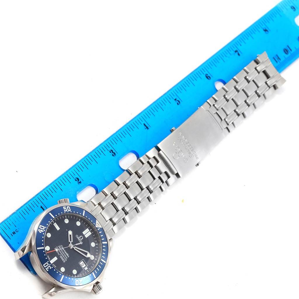 The image shows a top-down view of an Omega Seamaster 2531.80.00 Men
s Stainless Steel Blue Dial 2531.80.00 Men
s Stainless Steel Blue Dial watch with its stainless steel bracelet next to a blue ruler.