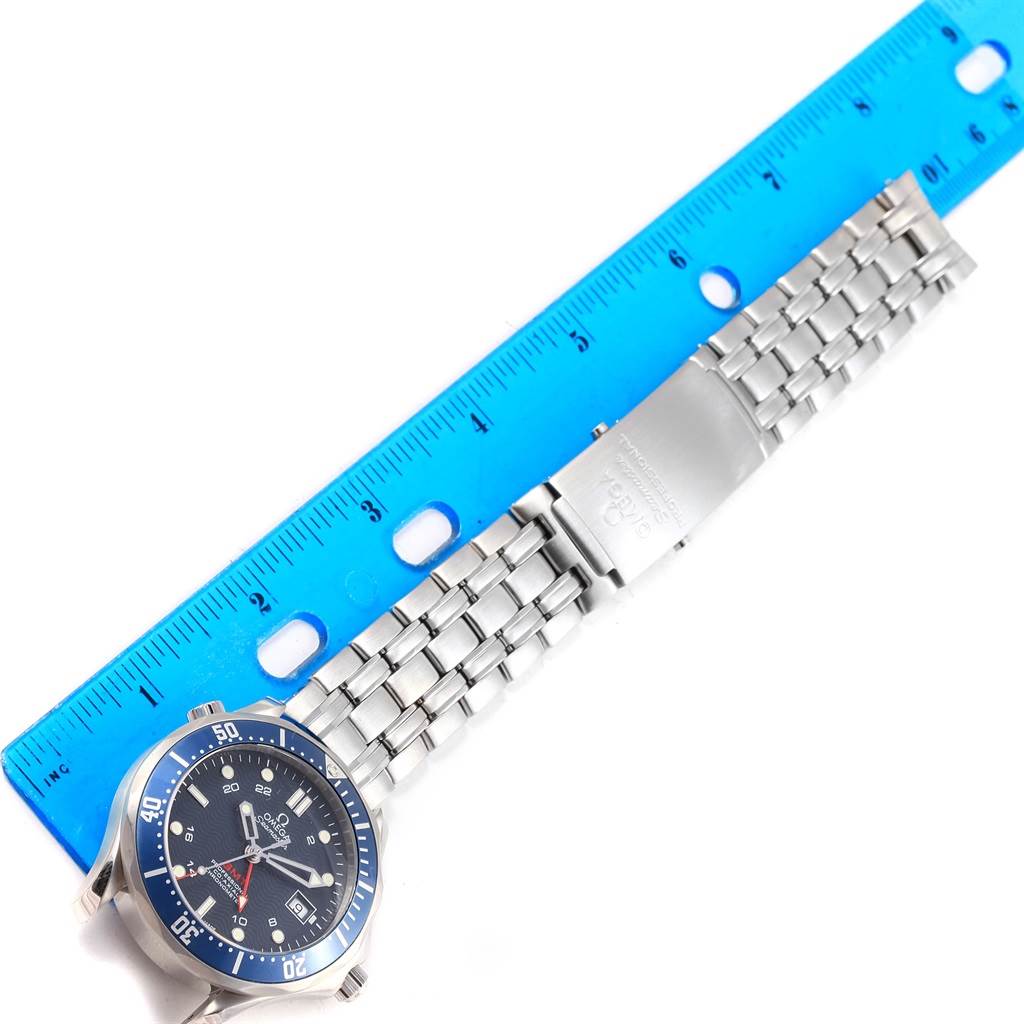 The image shows an Omega Seamaster 2535.80.00 Men
s Stainless Steel Blue Dial 2535.80.00 Men
s Stainless Steel Blue Dial watch laid flat next to a blue ruler, displaying the watch face and metal bracelet.