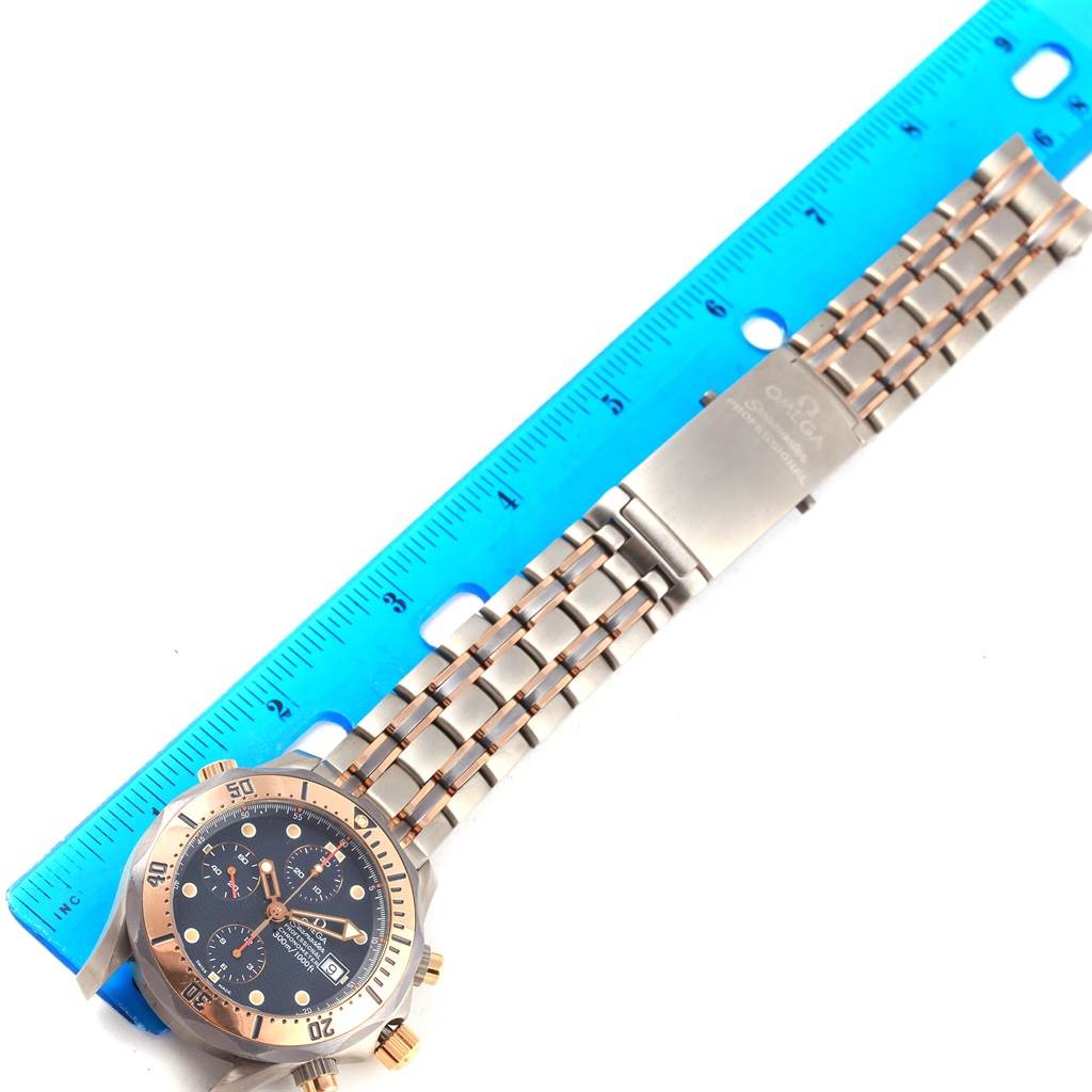 The image shows an Omega Seamaster 2296.80.00 Men
s Titanium Blue Dial 2296.80.00 Men
s Titanium Blue Dial watch from a top view, highlighting the dial, bezel, and metal bracelet alongside a blue ruler.