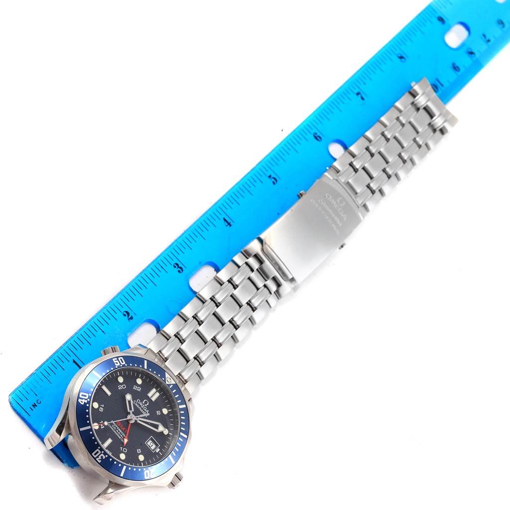 The image shows a top-down view of an Omega Seamaster 2535.80.00 Men
s Stainless Steel Blue Dial 2535.80.00 Men
s Stainless Steel Blue Dial watch with its metal bracelet extended beside a blue ruler.