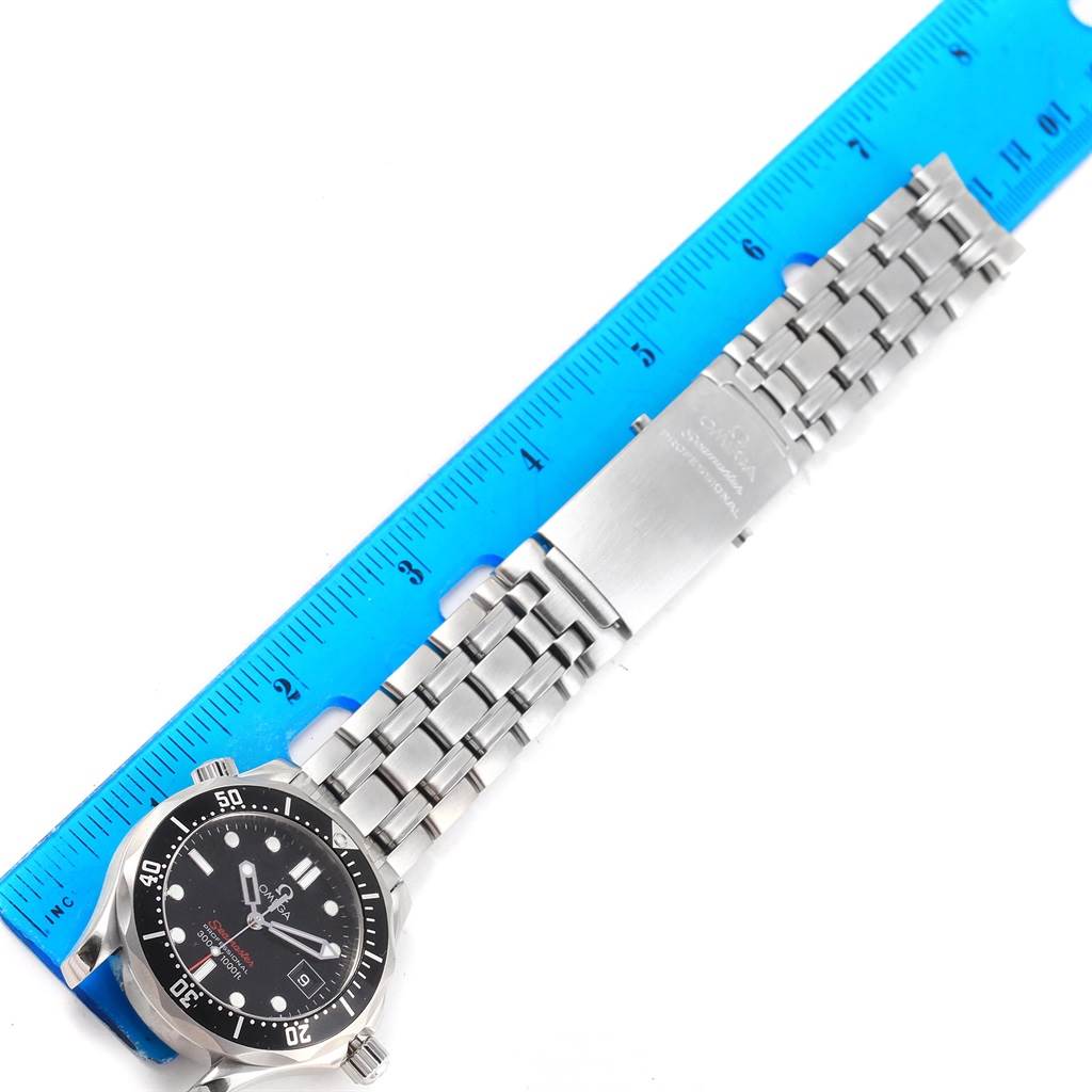 The image shows the Omega Seamaster 212.30.36.61.01.001 Men
s Stainless Steel Black Dial 212.30.36.61.01.001 Men
s Stainless Steel Black Dial watch laying flat next to a ruler, displaying the face, bezel, and full metal bracelet.