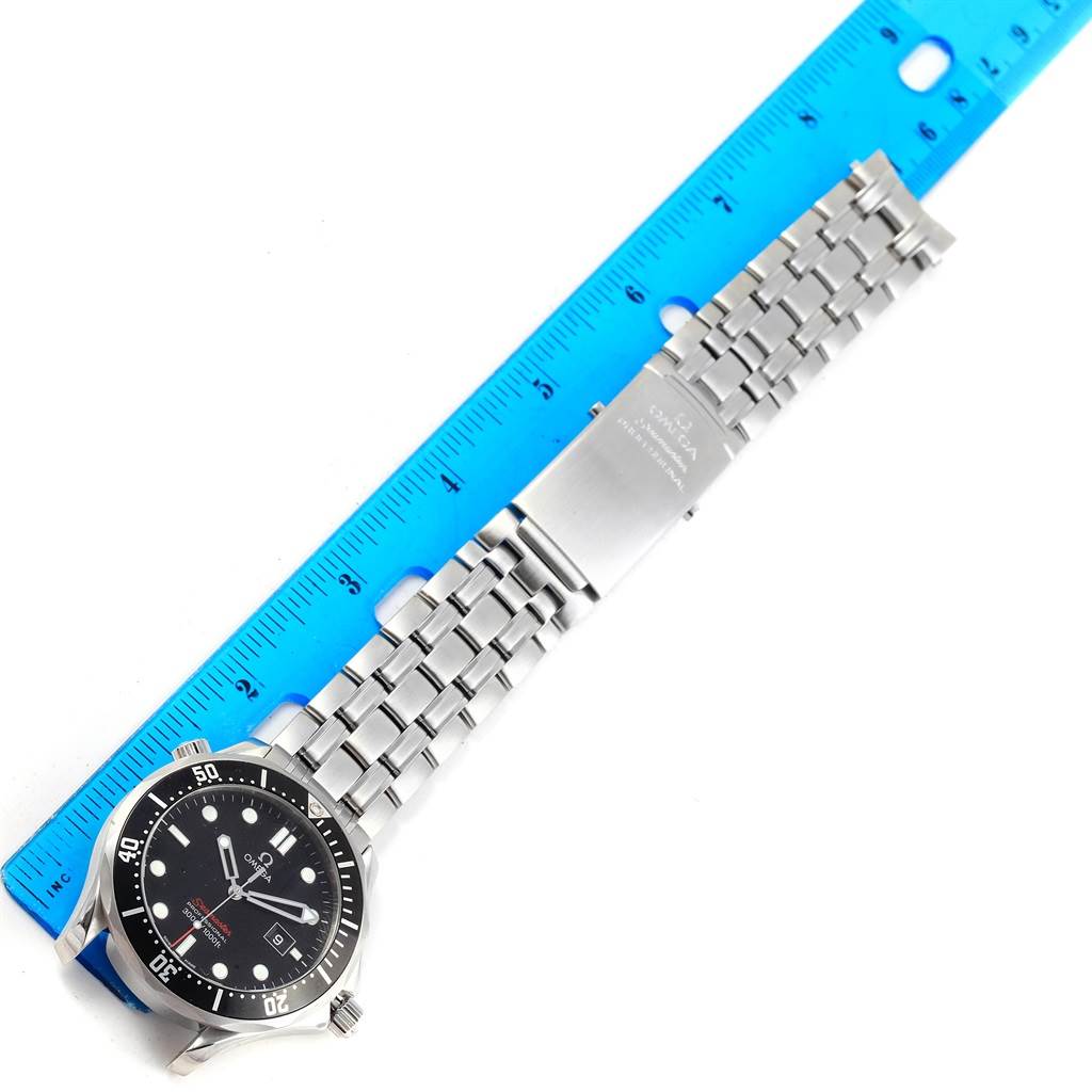 The Omega Seamaster 212.30.41.61.01.001 Men
s Stainless Steel Black Dial 212.30.41.61.01.001 Men
s Stainless Steel Black Dial watch is shown from a top-down angle, displaying the face, bezel, and metal bracelet beside a blue ruler.