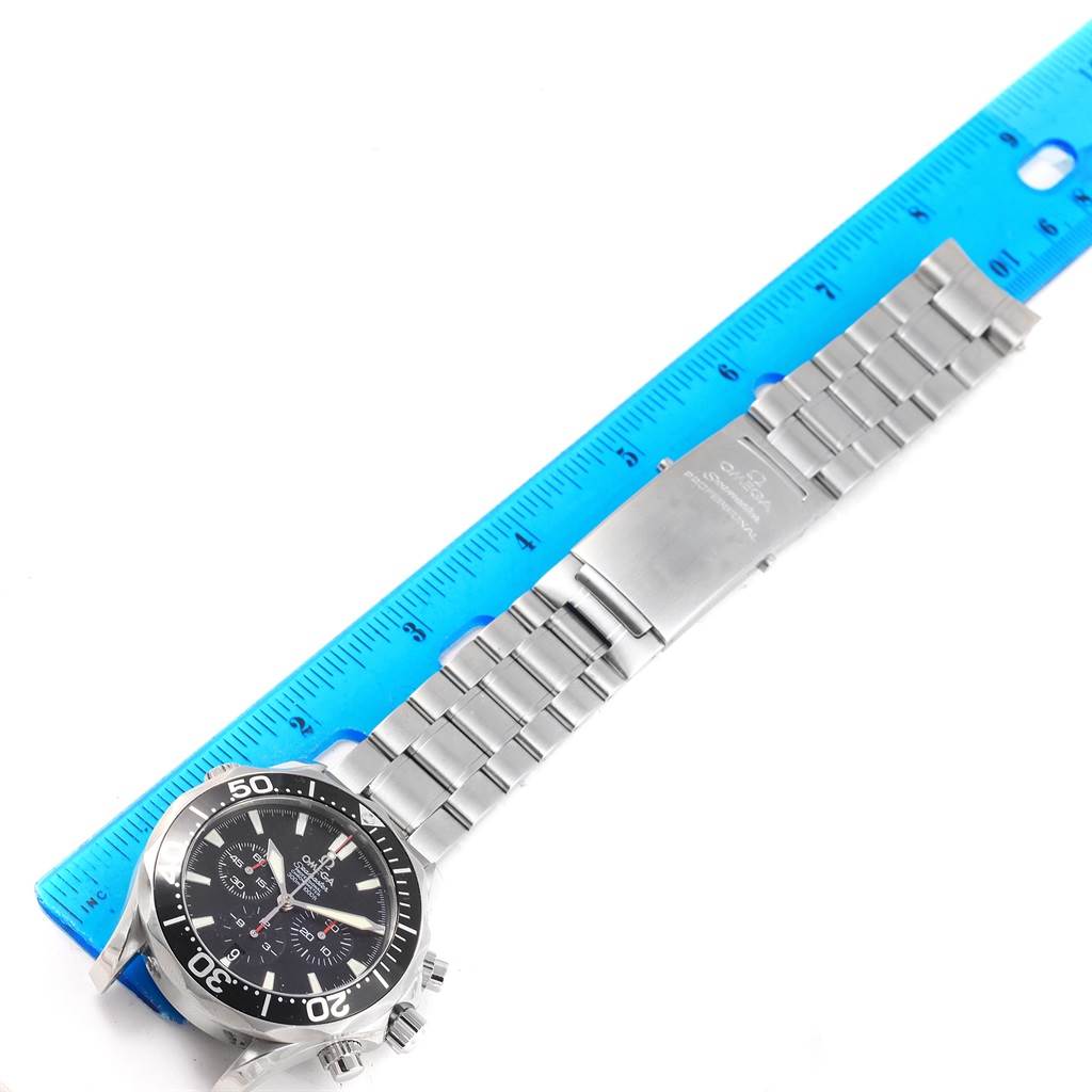 The Omega Seamaster 2594.52.00 Men
s Stainless Steel Black Dial 2594.52.00 Men
s Stainless Steel Black Dial watch is shown fully extended alongside a blue ruler, displaying the watch face and the metal bracelet.