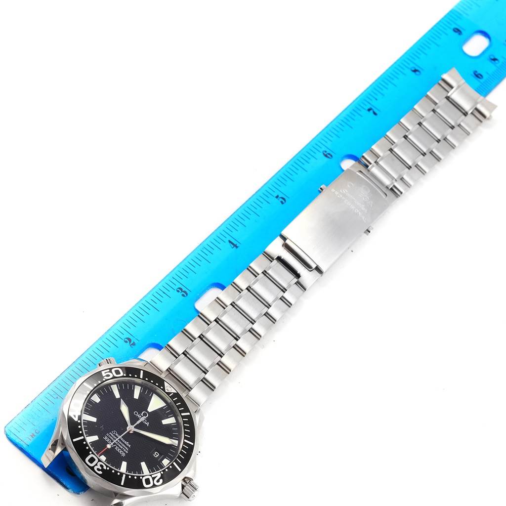 The image shows a full front view of the Omega Seamaster 2254.50.00 Men
s Stainless Steel Black Dial 2254.50.00 Men
s Stainless Steel Black Dial watch, including the face, bezel, crown, and metal bracelet, placed next to a blue ruler.